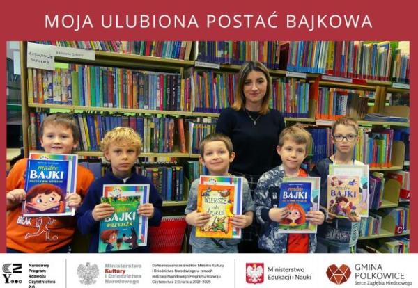 Laureaci z organizatorką konkursu stoją przed regałami z książkami w bibliotece